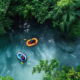 a group of people in colorful rafts navigating through turbulent waters surrounded by lush green trees